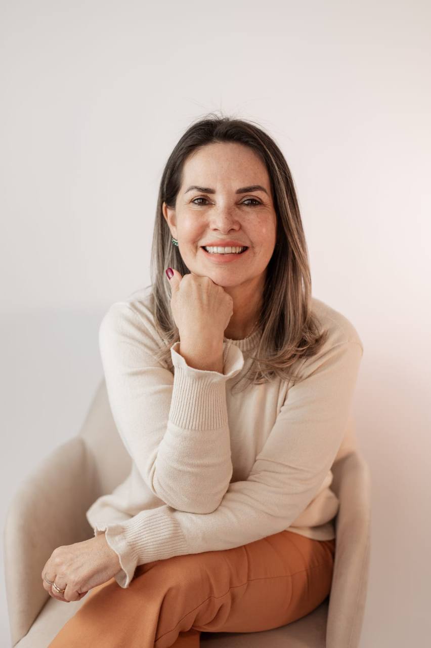 Liliane Limas sentada em uma poltrona, sorrindo